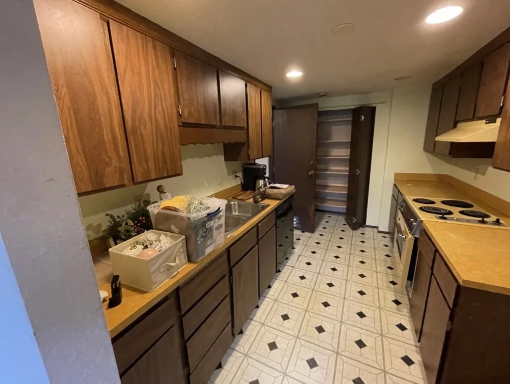 Kitchen with wood cabinets and protected countertops before painting